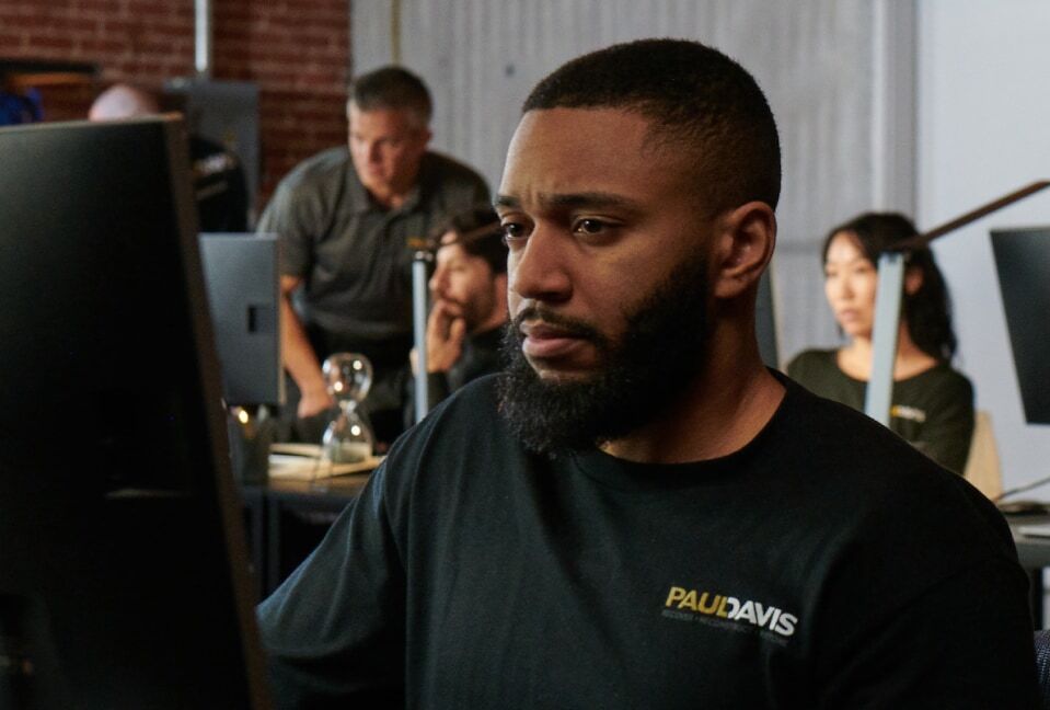 Paul Davis Restoration staff member working at a computer to help a customer